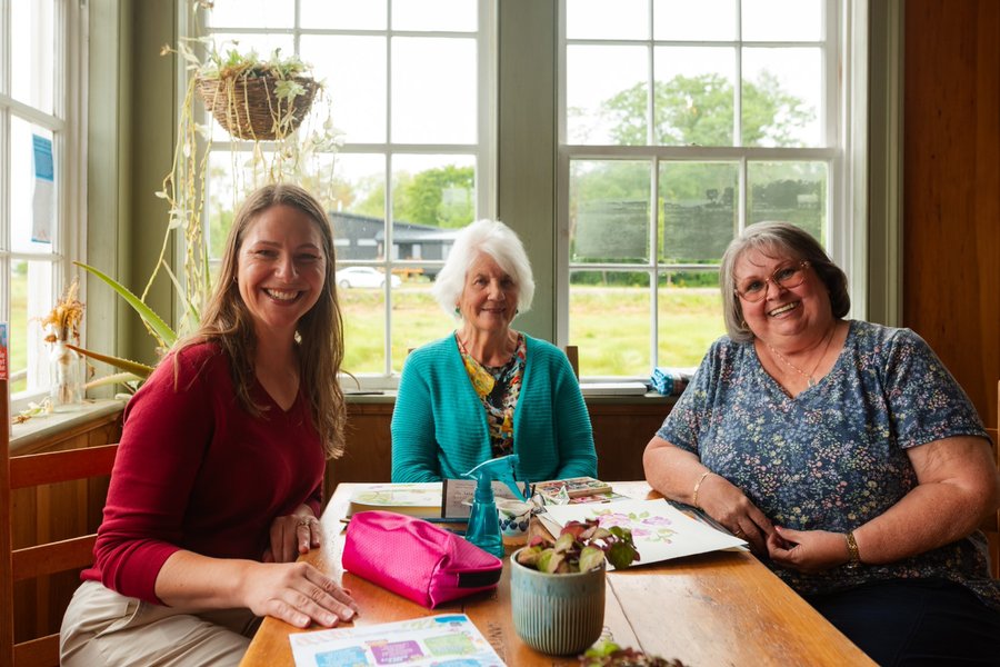 Becky Druhan in conversation with two women around a table